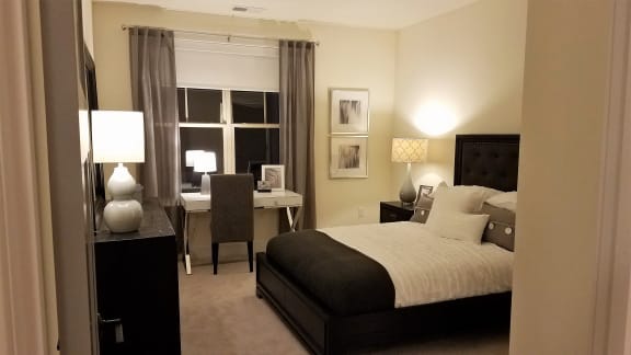 a bedroom with a bed and a desk and a window