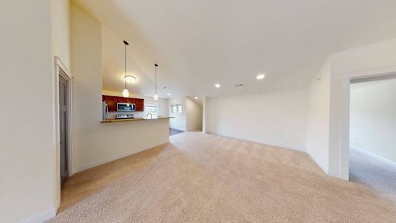 A long, empty hallway with a carpeted floor and white walls.