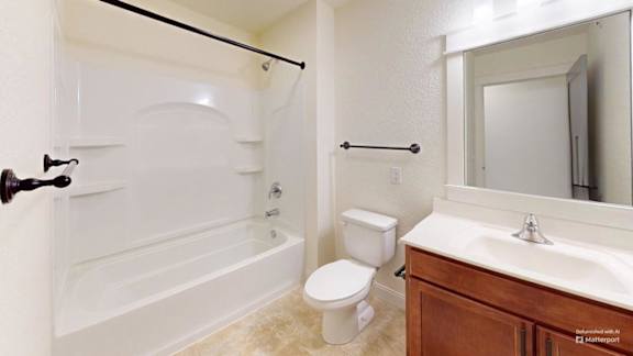 A bathroom with a toilet, sink, and bathtub.