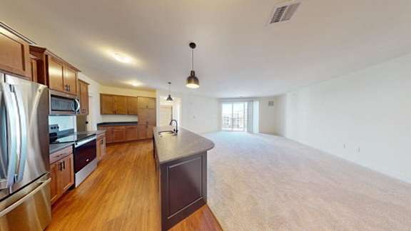 A kitchen with wooden floors and a large island in the middle.