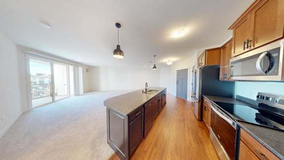 A kitchen with wooden cabinets and a large island.