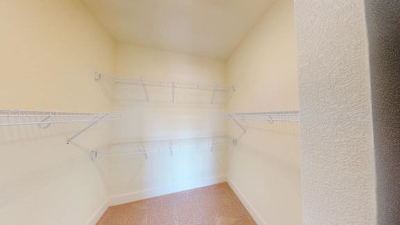 A small, empty room with a brown carpet and white walls.
