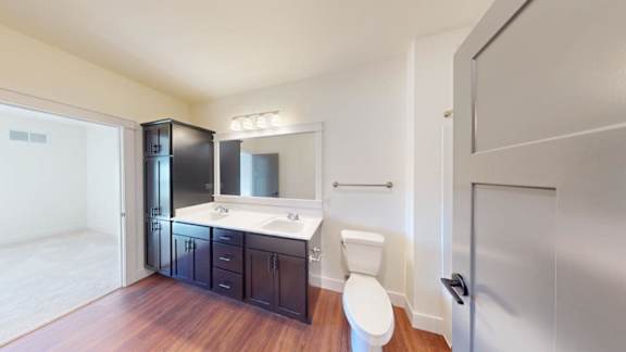 A bathroom with a toilet, sink, and mirror.