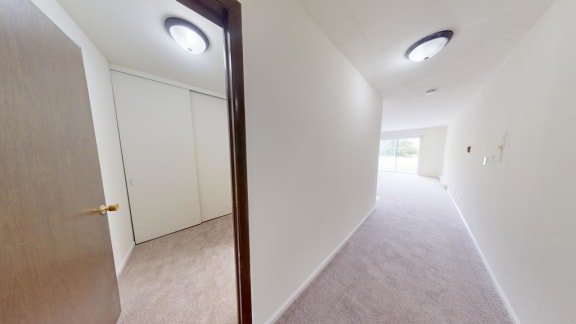 a hallway with a closet and a door to a bedroom
