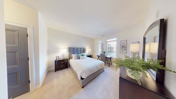 A bedroom with a bed, dresser, and mirror.