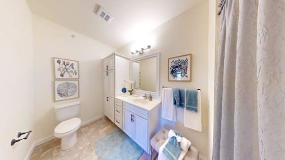 A bathroom with a toilet, sink, and mirror.