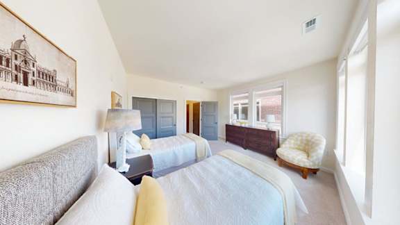 A bedroom with a bed, a couch, and a chair.