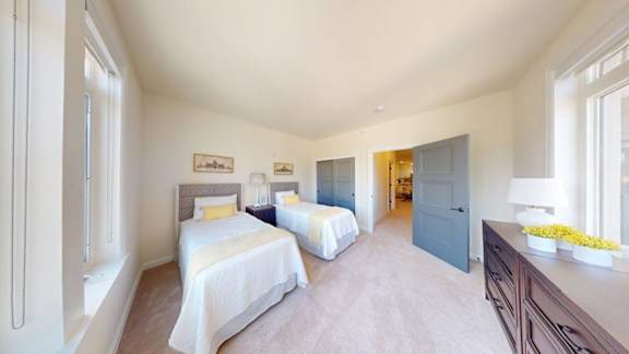 A bedroom with two beds and a dresser.