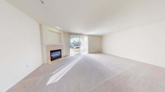 an empty living room with a fireplace and a window