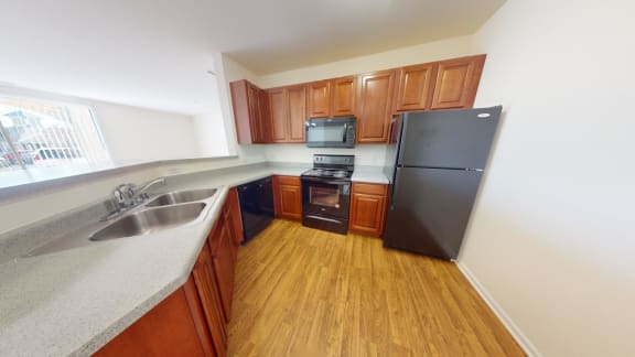 a kitchen with wood flooring and a stainless steel refrigerator