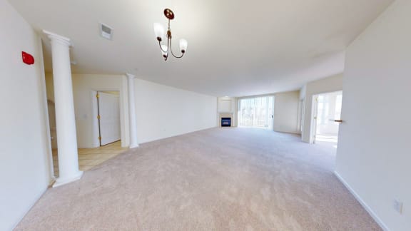 the living room and dining room of an empty home with white walls and carpet