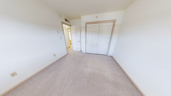 the living room and bedroom of an empty house with white walls and carpet