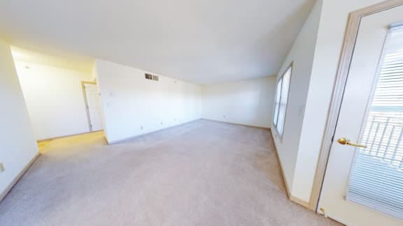the living room and bedroom of an empty home with white walls and carpet