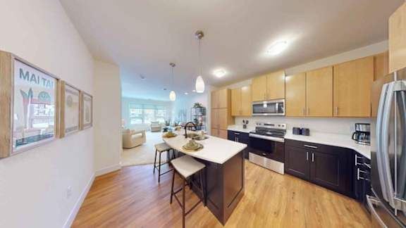 A kitchen with wooden floors and a white counter.