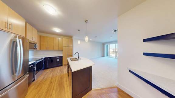 A kitchen with wooden cabinets and a stainless steel refrigerator.