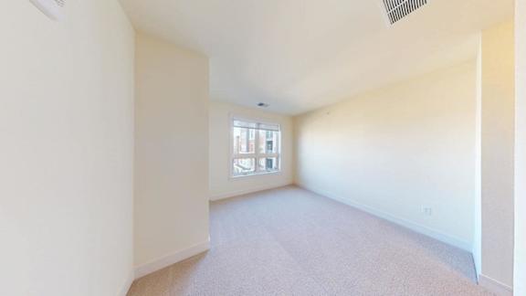 A room with a window and carpeted floor.