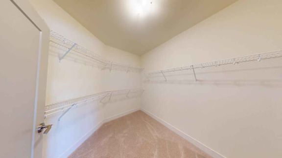 A room with a white wall and a door on the left side.