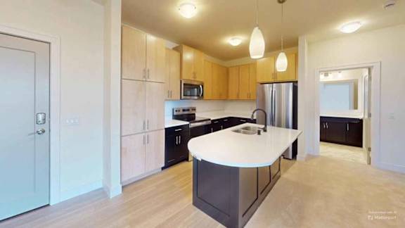 A modern kitchen with wooden cabinets and a white island.