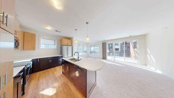 A kitchen with wooden floors and a large island in the middle.
