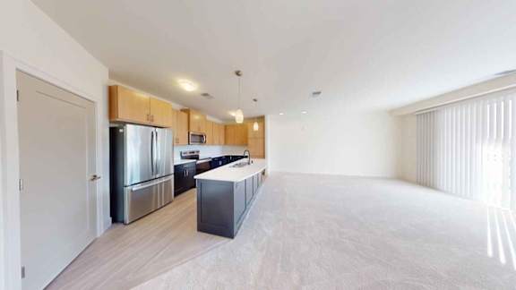 A kitchen with a refrigerator, sink, and cabinets.