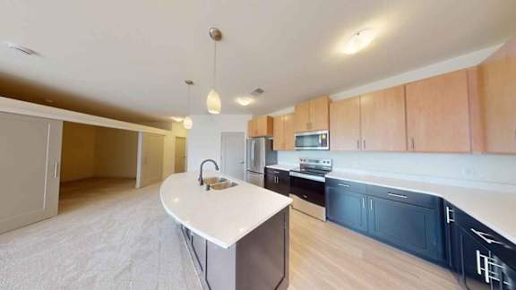 A kitchen with a white countertop and wooden cabinets.