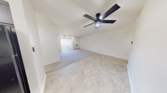 a living room with a ceiling fan and a large empty room