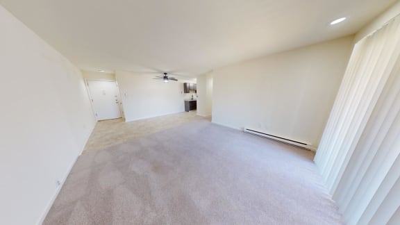 an empty living room with white walls and carpet