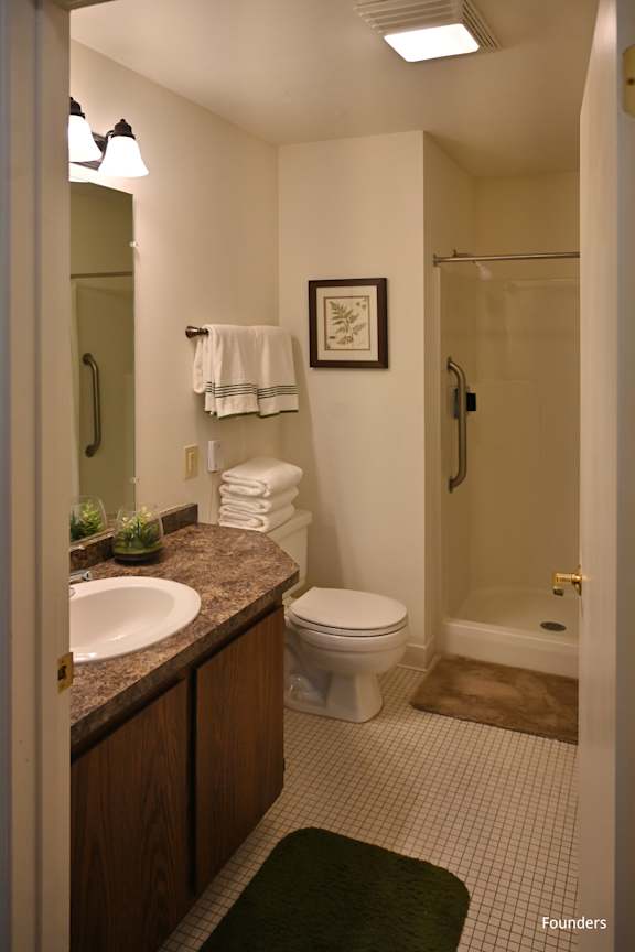 A bathroom with a sink, toilet, and shower.