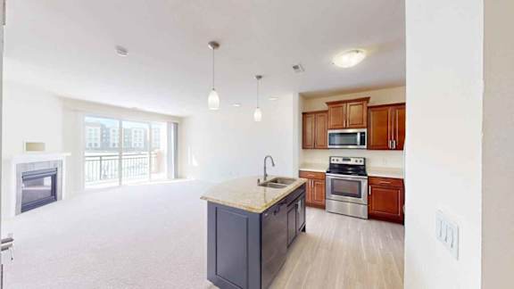 A kitchen with a black counter top and wooden cabinets.