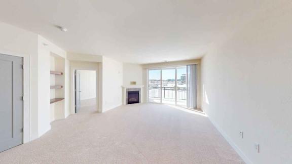 A spacious room with a fireplace and a large window.