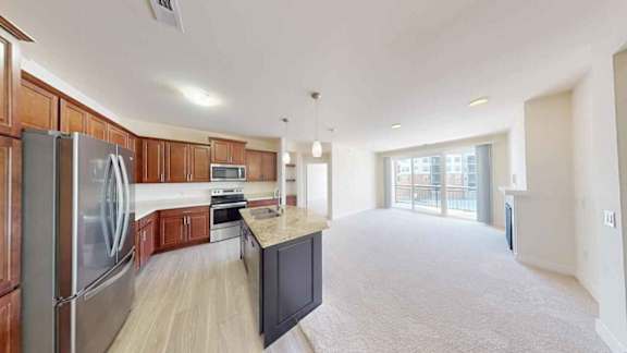 A kitchen with wooden cabinets and a stainless steel refrigerator.