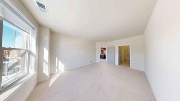 A large empty room with a window on the left side.