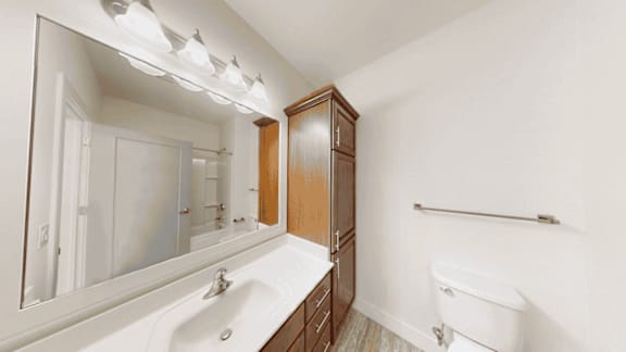 A white sink in a bathroom with a wooden cabinet.