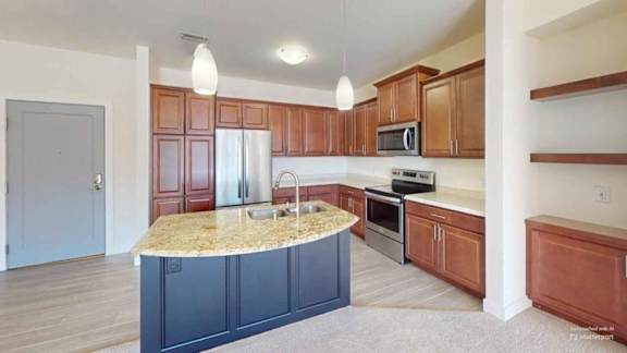 A kitchen with a granite countertop and wooden cabinets.