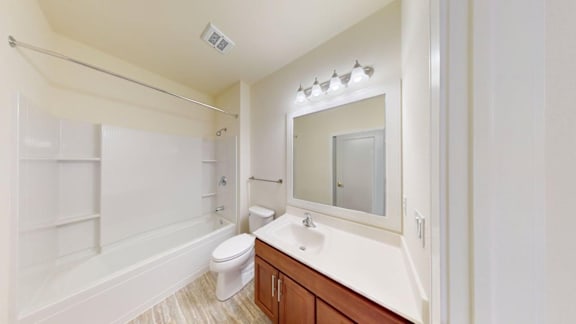 A white bathroom with a toilet, sink, and mirror.