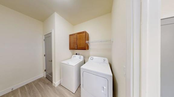 A white washing machine and dryer in a small room.