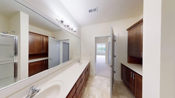 A bathroom with a white sink and a large mirror.