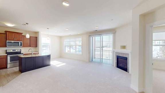 A spacious living room with a fireplace and sliding glass doors.