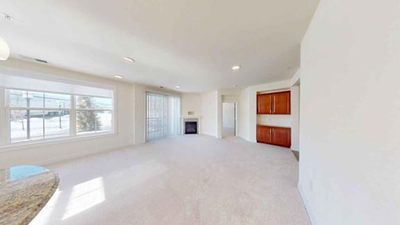 A spacious room with a fireplace and large windows.
