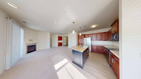 A spacious kitchen with wooden cabinets and a marble countertop.