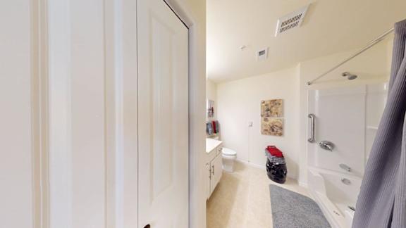 A bathroom with a white tub and a white door.