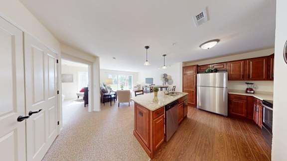 A kitchen with wooden cabinets and a stainless steel refrigerator.