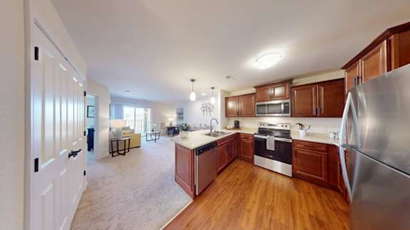 A kitchen with wooden cabinets and a stainless steel refrigerator.