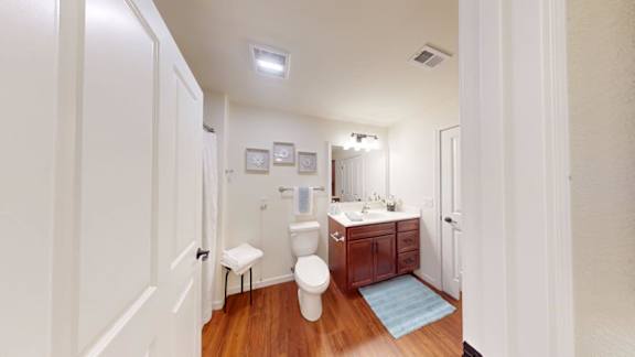 A small bathroom with a toilet, sink, and mirror.