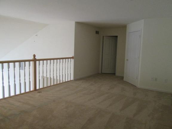 A room with a wooden floor and a white door.