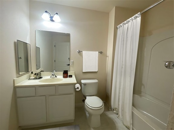 a bathroom with a toilet and a sink and a shower