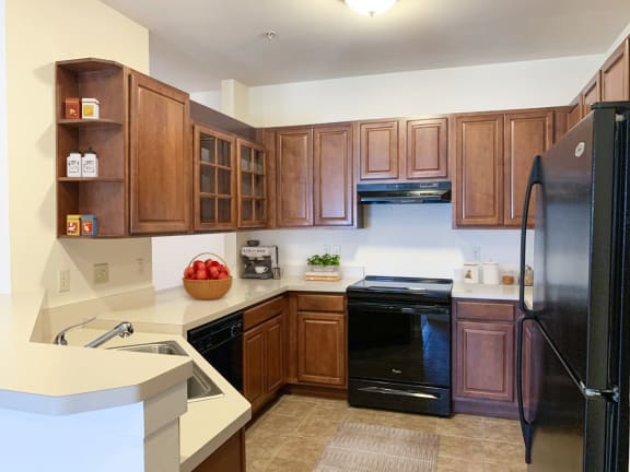 a kitchen with black appliances and wooden cabinets