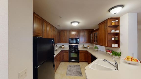 a kitchen with black appliances and wooden cabinets