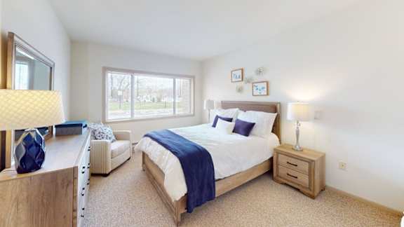 A bedroom with a large bed and a window.