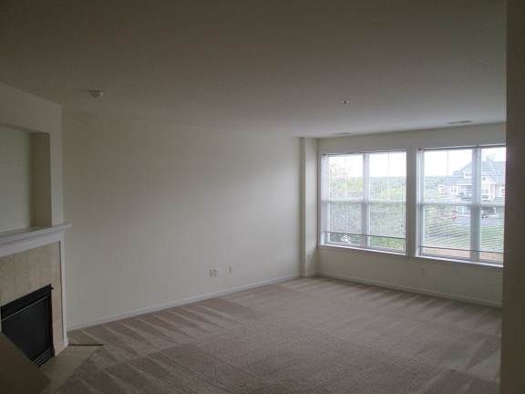 A living room with a fireplace and carpeted floor.